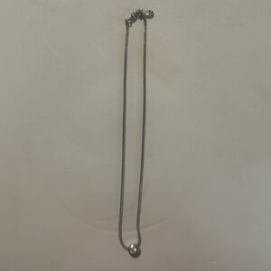 Silver necklace with rhinestone or cubic zirconia.